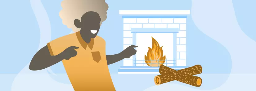 Person, die vor dem brennenden Kamin steht